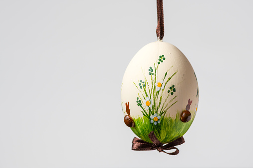 Closeup of a beautiful hand painted easter egg hanging on a brown string