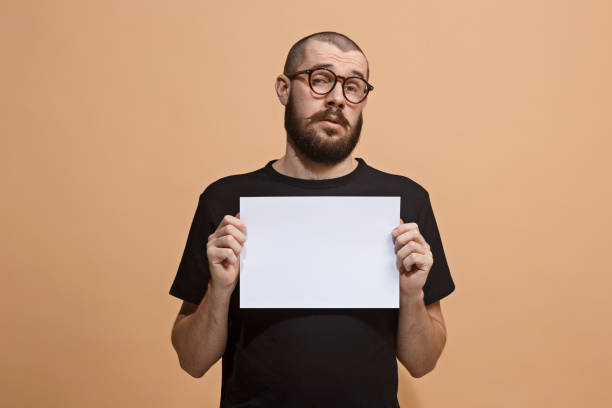 ein junger mann hält einen leeren teller in der hand, ihren text zu füllen. emotionale, mutige gesicht - hand sign human arm human hand holding stock-fotos und bilder