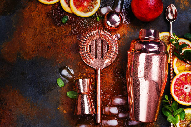 Bar accessories, drink tools and cocktail ingredients on rusty stone table. Flat lay style stock photo