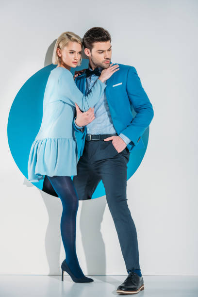 istock fashionable young couple stepping from blue hole on grey 925812338