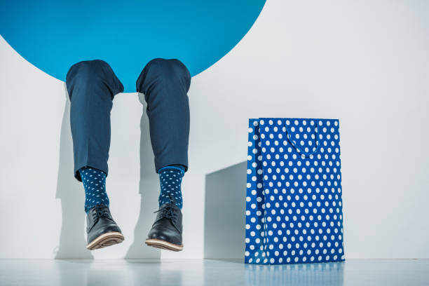 istock partial view of stylish young man with shopping bag falling into hole on grey 925815598