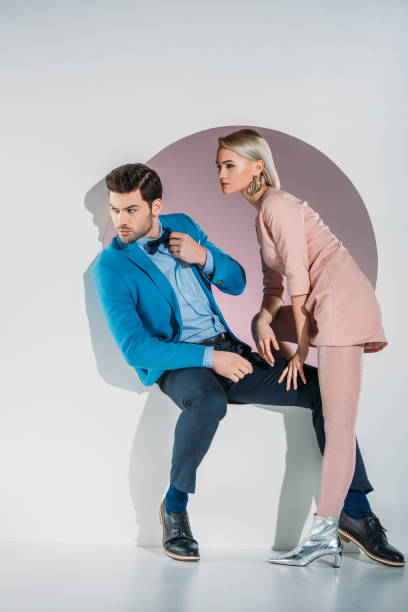 istock beautiful young couple looking away while sitting together in aperture on grey 925816382