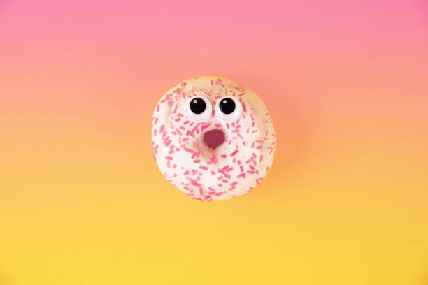 istock Colorful glazed donuts with funny eyes on yellow background 925820096