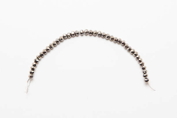 istock Black silver and gold beads isolated on white 925825600
