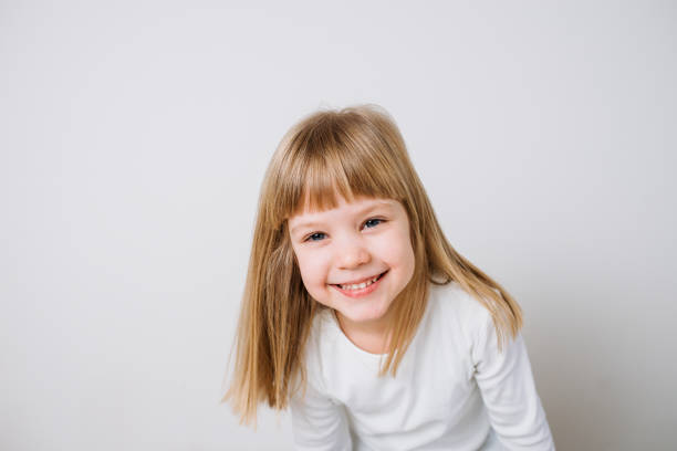 istock Smiling little girl dressed in white on isolated background. 925831728
