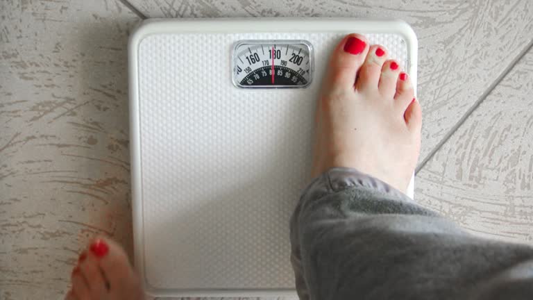 Female Standing on Weight Scale (HD)