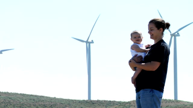 Mother and baby portrait by wind turbines