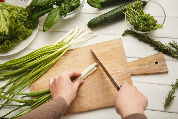 istock Woman cutting spring onion for salad 925841064