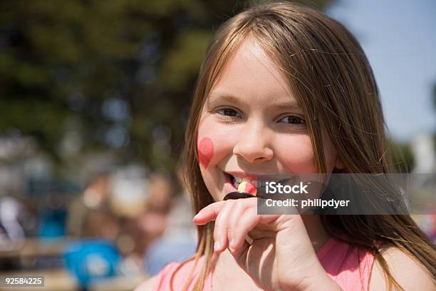 Girl Eating Candy At Festival Stock Photo - Download Image Now - Child, Heart Shape, Traditional Festival