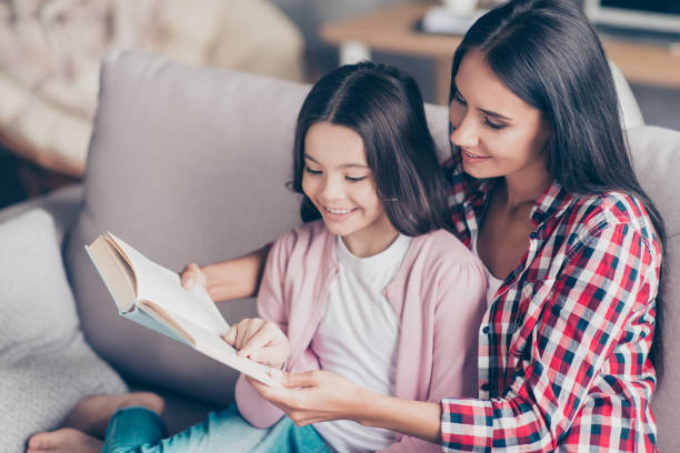 istock It's so interesting and exciting! Young smiling mother is reading a funny book for her cute sweet little daughter, they are doing homework and embracing and spending time together 925850140