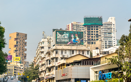 This image showcases Horniman Circle, a prominent landmark in Mumbai's Fort area. Known for its well-planned and elegant layout, Horniman Circle is a testament to the city's colonial past, featuring a large park surrounded by neo-classical buildings. The photograph captures the circle's tranquil and leafy park, a rare oasis of green in the bustling city, fringed by the stately facades of historic structures. The area is a popular spot for both locals and office-goers, offering a peaceful respite amidst the urban hustle. The image aims to convey the charm and historical significance of Horniman Circle, highlighting its role as a blend of cultural heritage and urban green space in the heart of Mumbai.