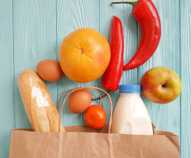 istock paper bag with different useful food on blue wooden 925853358