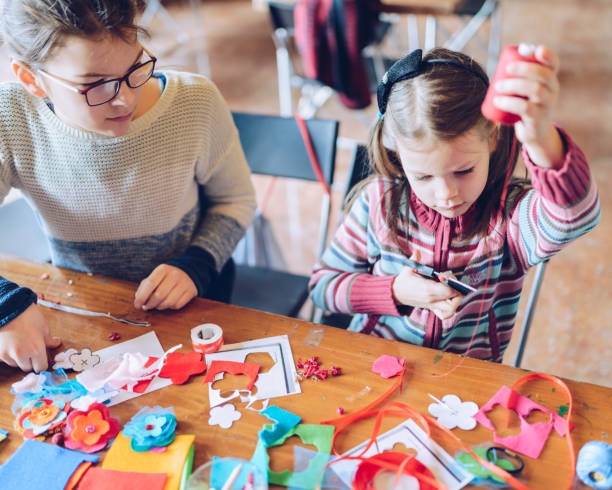 istock tailor art workshops for children - a girl sewing felt decorations 925853680