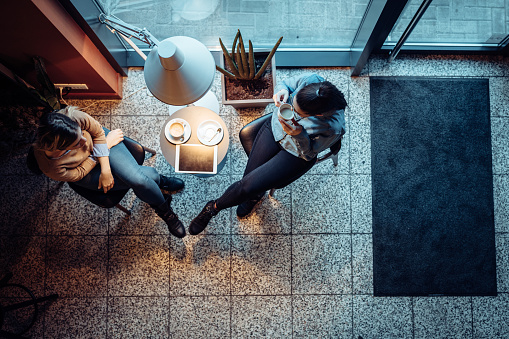 Two female friends hanging out in a coffee shop