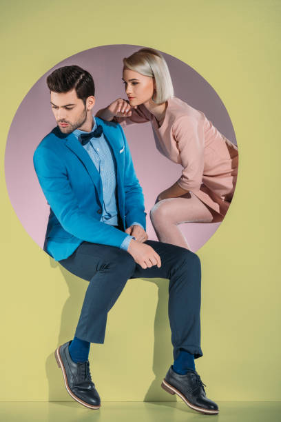 istock beautiful couple in stylish clothes looking down on yellow 925857544