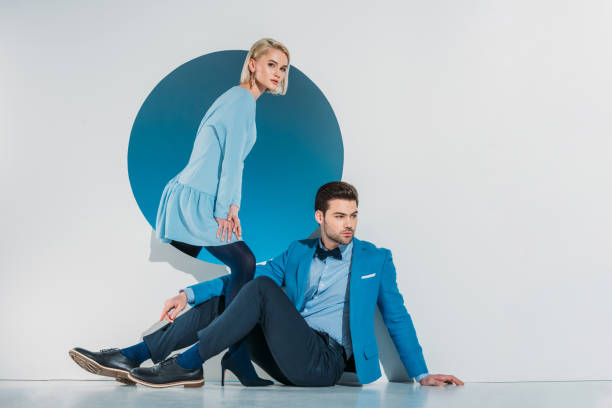 istock attractive stylish couple sitting and looking at camera on grey 925857868