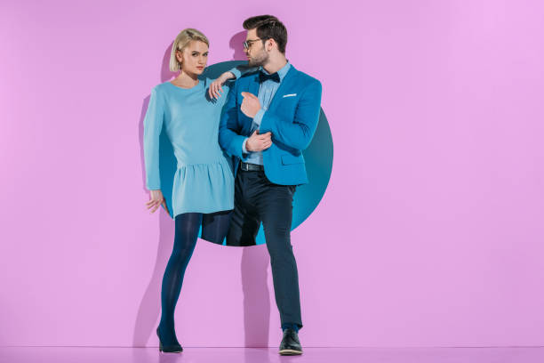 istock attractive stylish couple stepping through aperture on purple 925860658