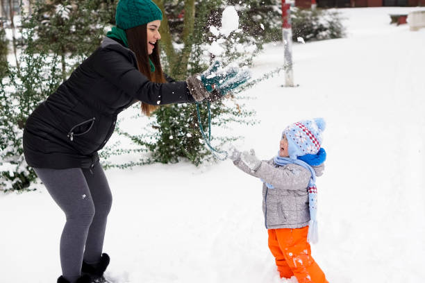 istock Mother and little son having fun in the snow 925861338