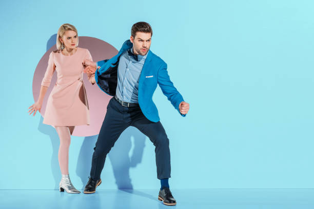 istock angry boyfriend going with fashionable girlfriend through aperture on blue 925864422