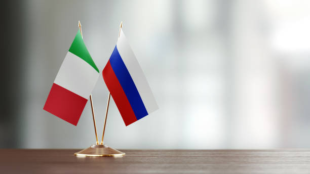 istock Italian And Russian Flag Pair On A Desk Over Defocused Background 925865610