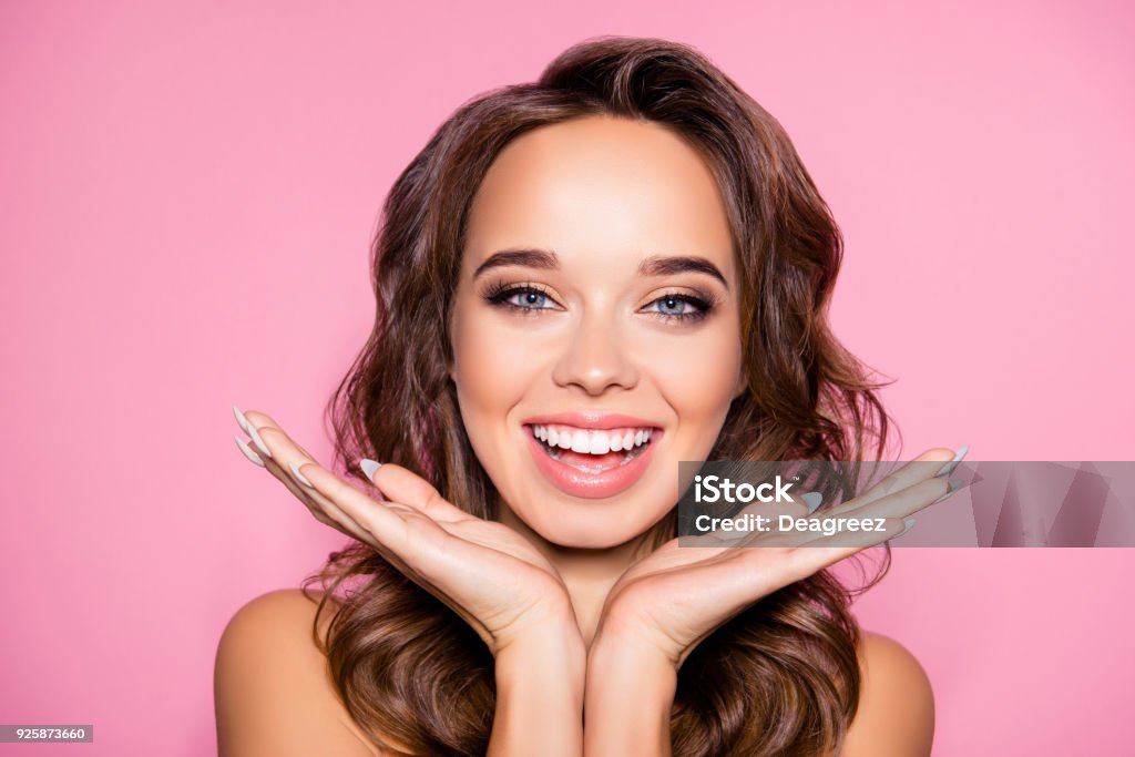 Aging, acne, pimples, wrinkles, oily, dry skin concept. Close up cropped photo of pretty excited lady with wavy hairdo, arm palms near face, happiness and freshness, purity Skin Stock Photo