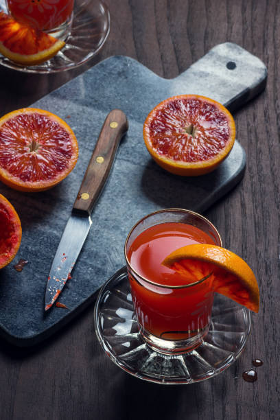 istock Freshly Squeezed Blood Orange Juice with Orange Halves on Cutting Board 925873712