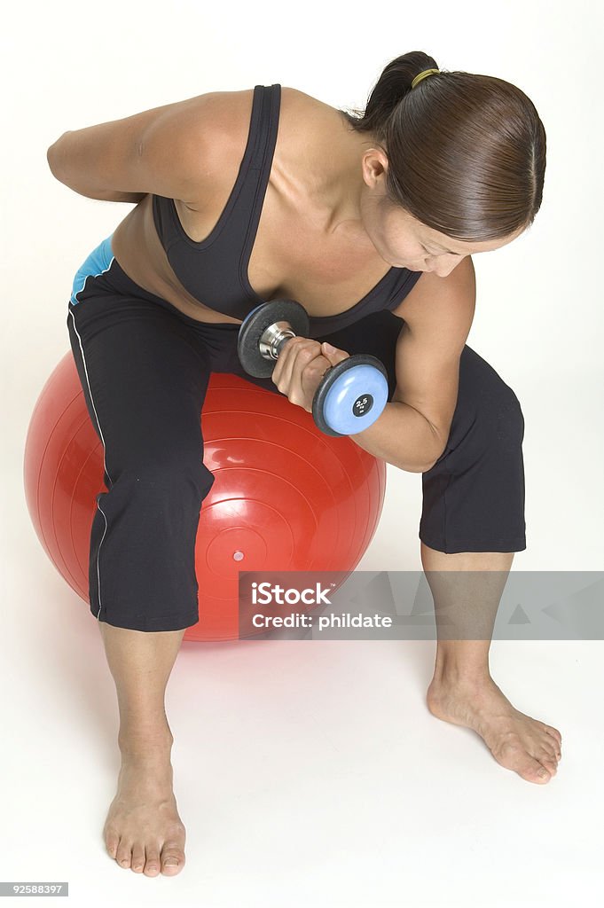 Concentration Curl 4 A female fitness instructor demonstrates the finsihing position of the dumbbell concentration curl Adult Stock Photo