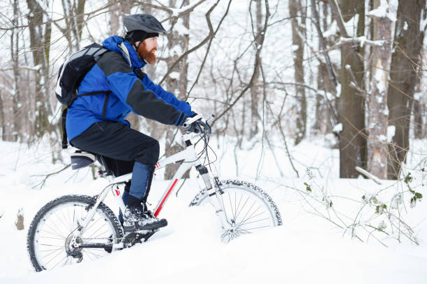 istock Determined young man riding mountain bike through deep snow 925884516