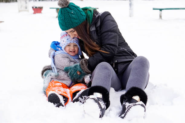 istock Mother and little son having fun in the snow 925889346