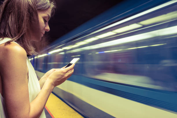 Woman at subway station using smartphone to see the map