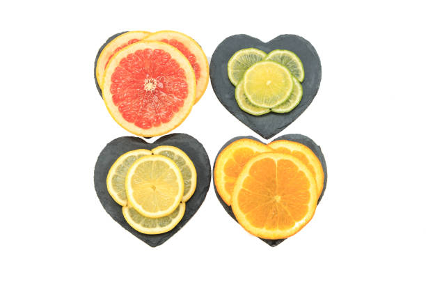 Sliced Citrus fruits, orange, pink grapefruit, lemon and lime on heart shaped slate trays