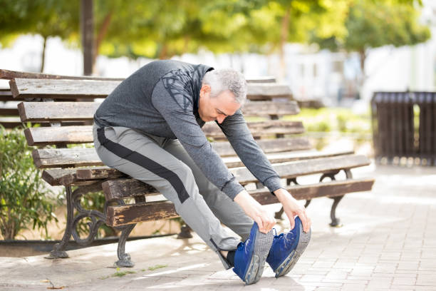 istock Middle aged man exercising on a park bench 925904924