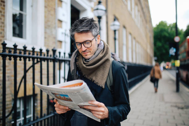 vintage portrait of a man reading newspapers in london downtown - reading newspaper 30s adult imagens e fotografias de stock