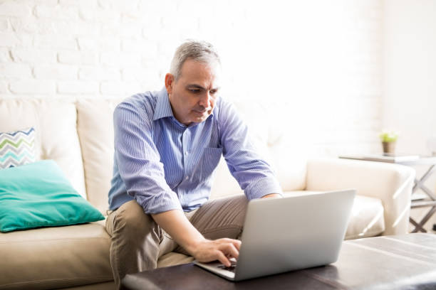 istock Mature man working on laptop at home 925912044