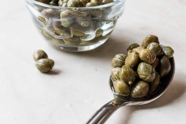 Edible Capers in Spoon Ready to Eat. Edible Capers in Spoon Ready to Eat. Organic Food. caper stock pictures, royalty-free photos & images