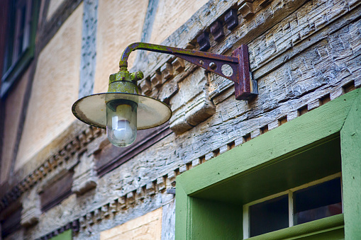 closeup of streetlamp hanging above old door at vintage house
