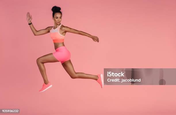 Healthy African Woman Sprinting On Pink Background Stock Photo - Download Image Now - Women, One Woman Only, Sport