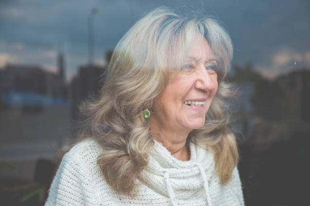 istock Senior woman looking through the window 925952722
