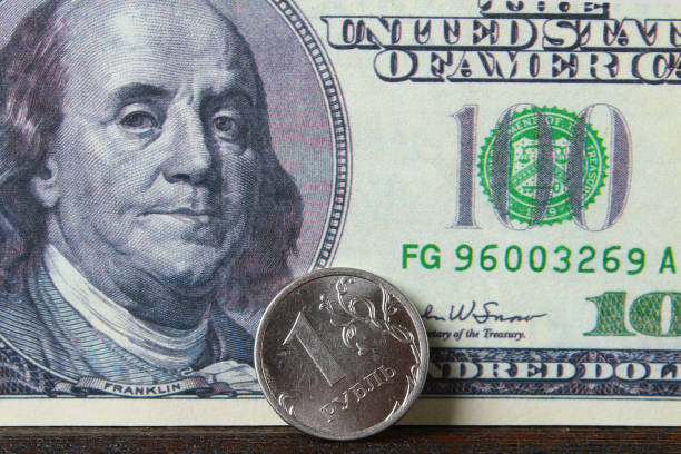 istock coin one ruble against the background US dollars background. 925965848