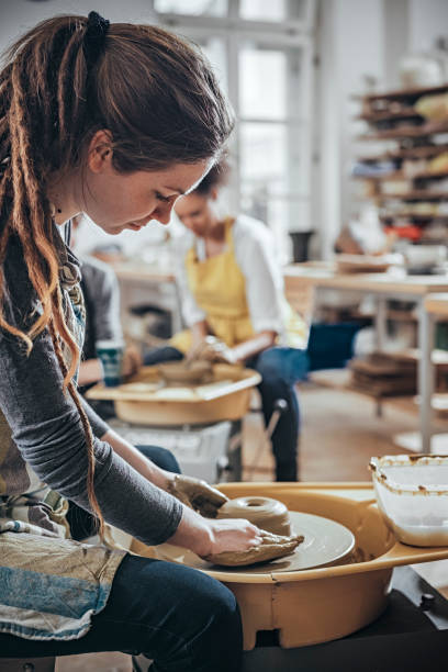 istock Young Woman making ceramic work with potter's wheel 925971632