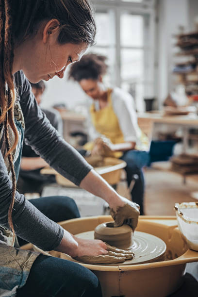 istock Young Woman making ceramic work with potter's wheel 925971772