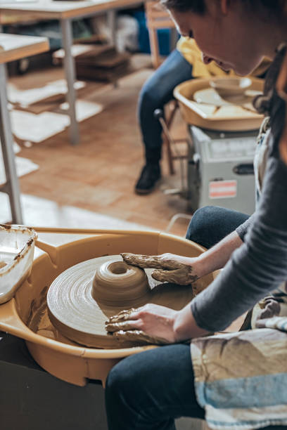 istock Young Woman making ceramic work with potter's wheel 925971856