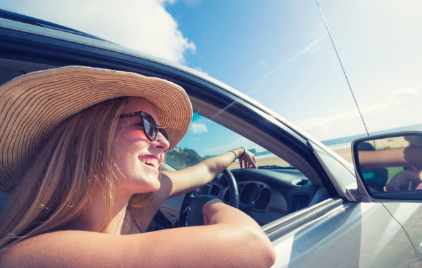 istock Young woman driving a car on the beach. 925980100