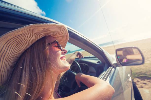 istock Young woman driving a car on the beach. 925980102