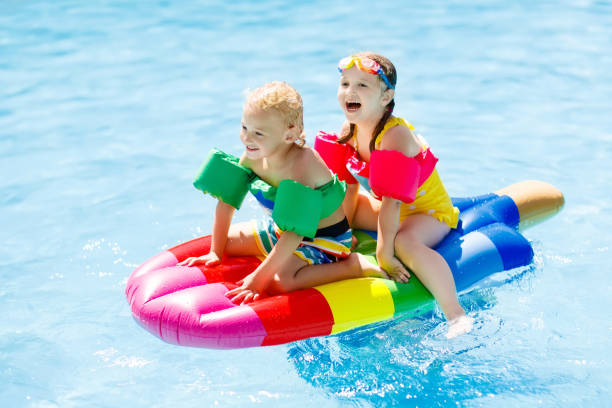 istock Kids on inflatable float in swimming pool. 925984300