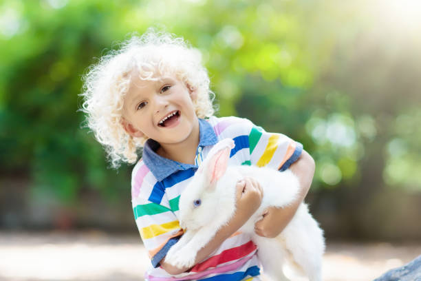 istock Child with rabbit. Easter bunny. Kids and pets. 925985230