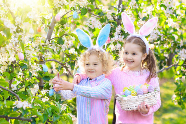 istock Easter egg hunt. Kids with bunny ears and basket. 925988504