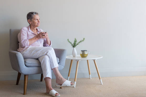 istock Older woman seated and looking pensive 926005176