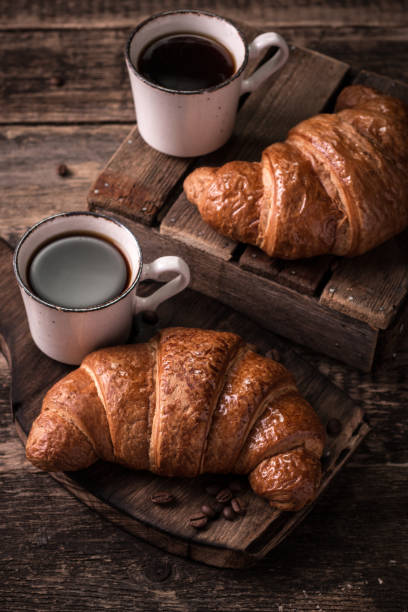 istock Breakfast with coffee and croissants on wooden vintage table 926010310