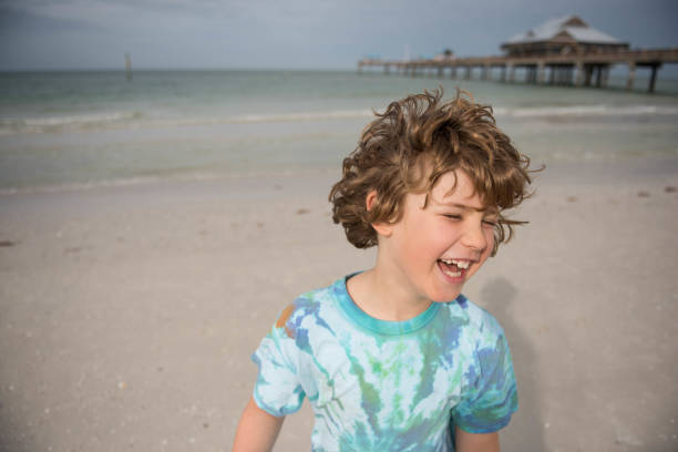 8 year old plays in the Gulf of Mexico on a beautiful evening, splashing, swimming, and running in the ocean